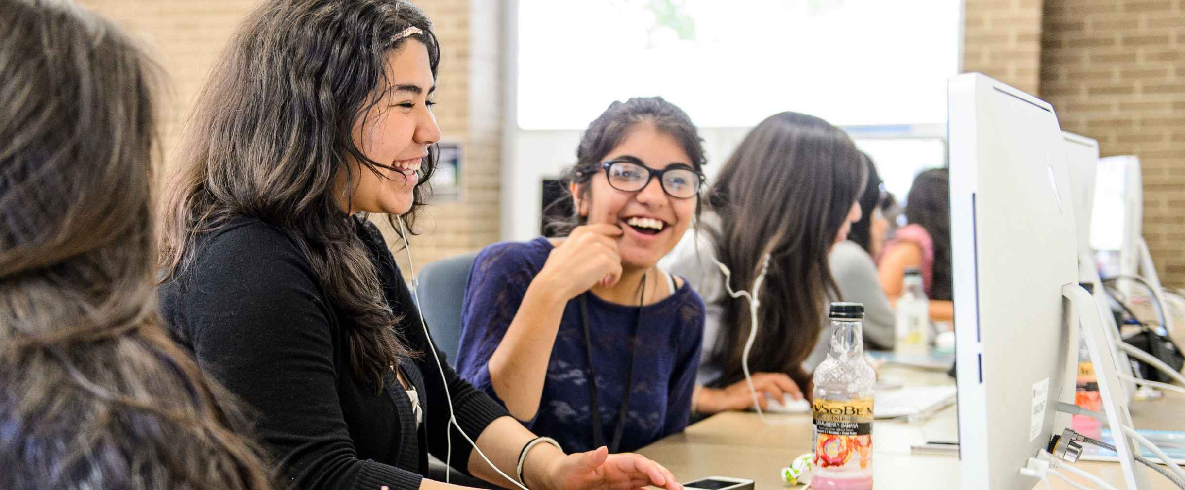 Girls laughing in front of computer