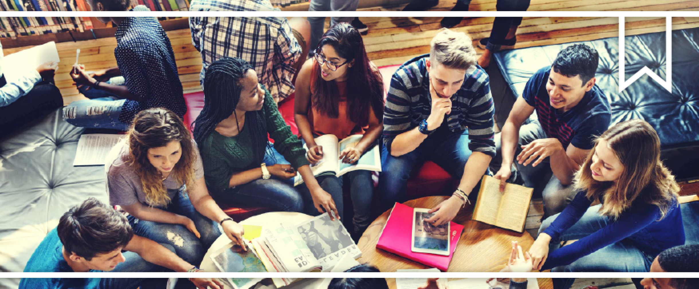 Group of young adults sitting in a circle talking with books open