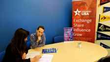 Young man and women sitting at a table reviewing documents