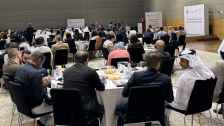 An audience of school counselors sitting in a ballroom listening to welcoming remarks by the Deputy Chief of Mission at the U.S. Embassy in Qatar