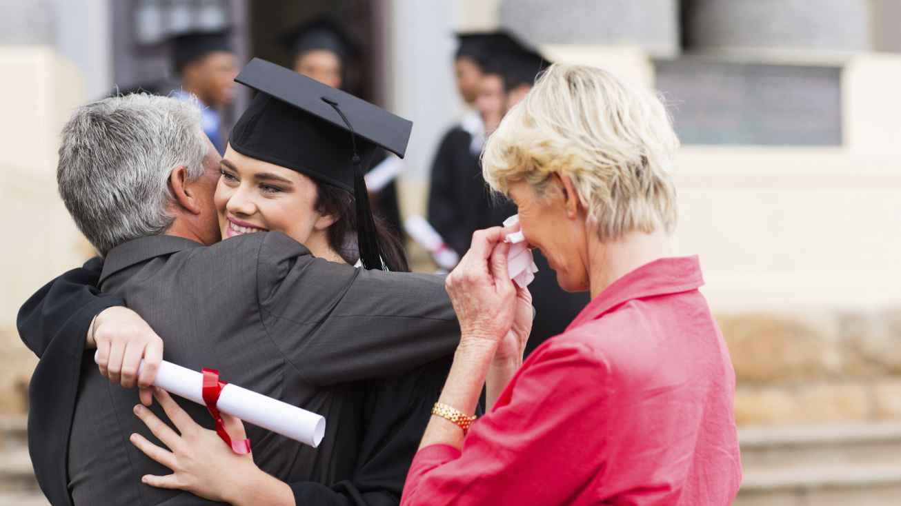 international student and emotional parents at college gradutation ceremony 